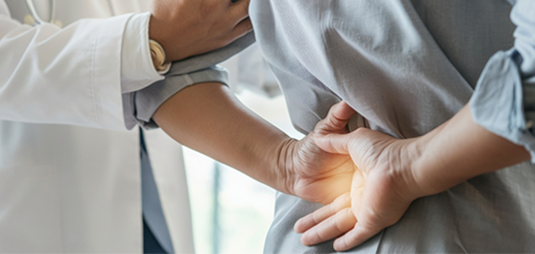 Doctor assessing patient experiencing lower back pain